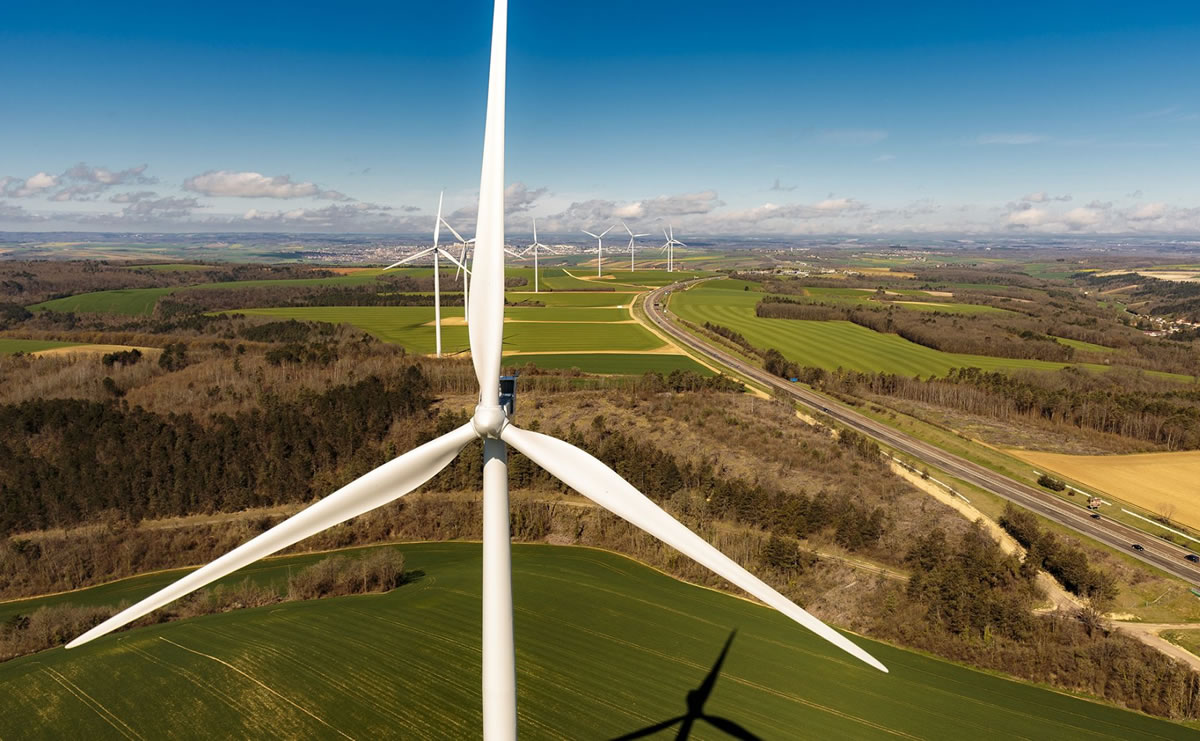 Champ d'éoliennes le long d'une autoroute